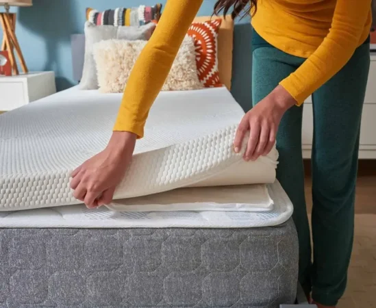 Woman putting a mattress topper on mattress