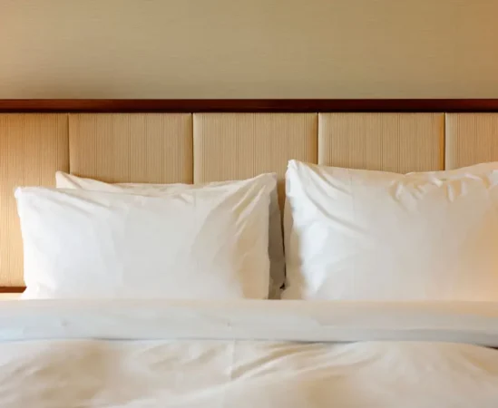 Hotel bed with white pillows and headboard