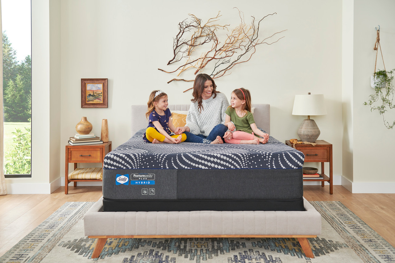 Family sitting on a Sealy hybrid mattress.