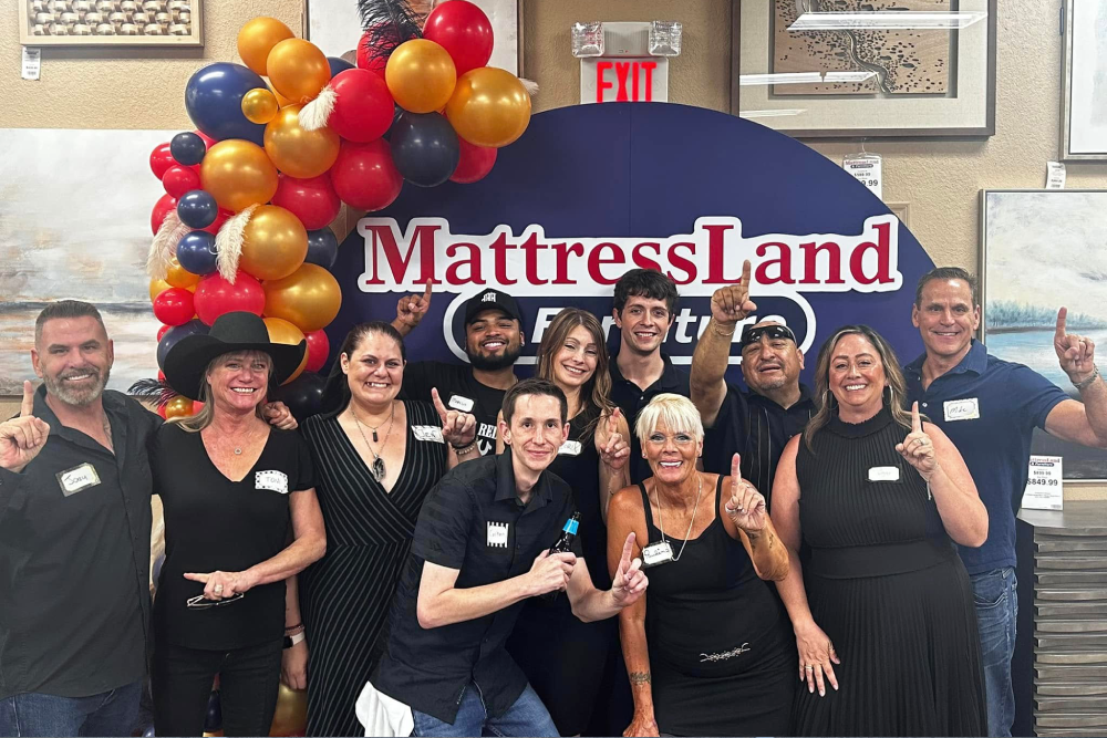 Group celebrating at MattressLand with balloons.